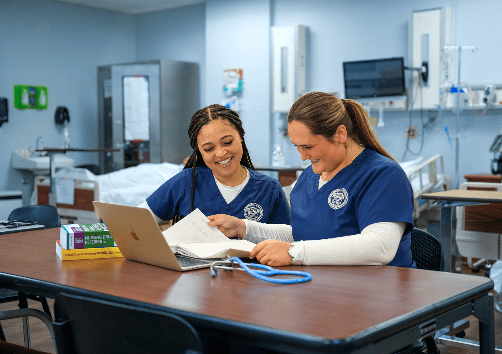 Two nursing students studying together in a Quincy College nursing lab