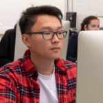 A dual enrollment high school student looking at a computer screen