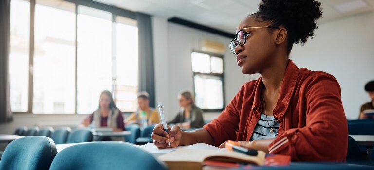 Young woman actively taking notes in a classroom