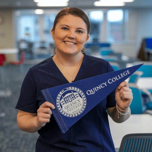 Student holding a Quincy College pennant flag