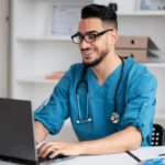 Male Healthcare Administration student wearing blue scrubs