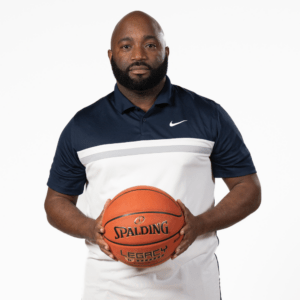 Assistant Coach Jamal Griffin holding a basketball 