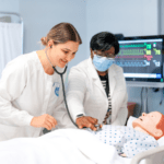 A practical nursing student and nursing professor practicing on a sim-robot