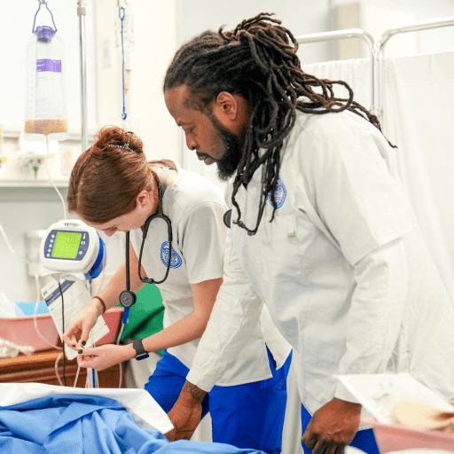 Two nursing students practicing in a lab
